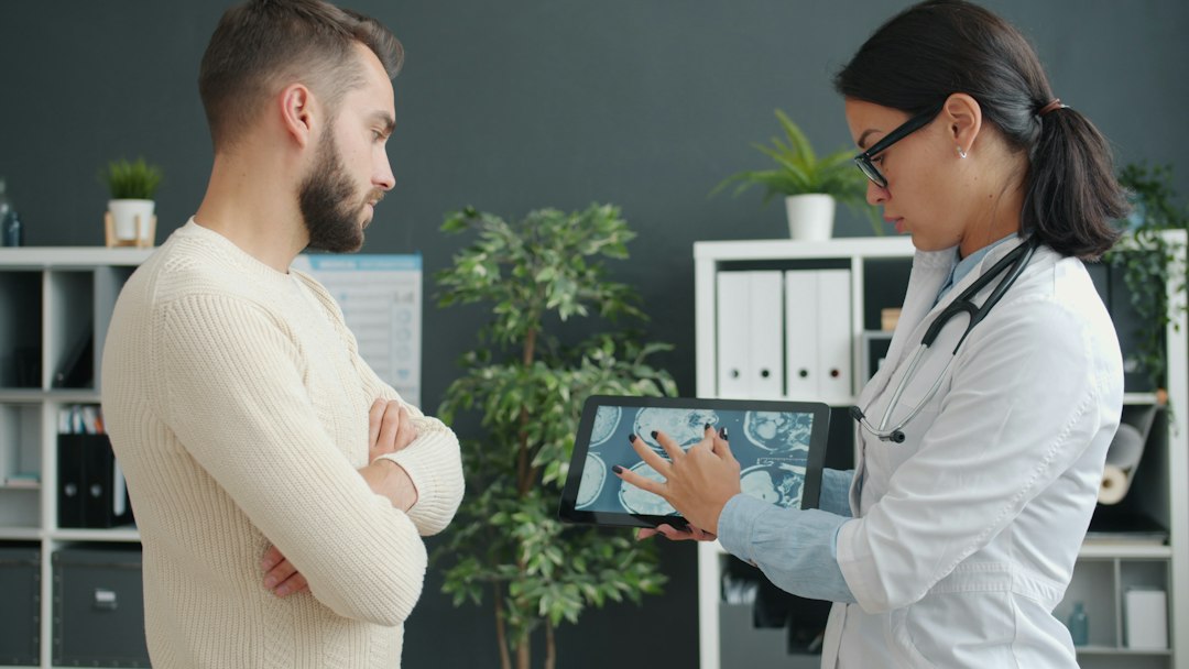 Clinician reviewing AI-generated musculoskeletal scan results on a tablet during a patient visit