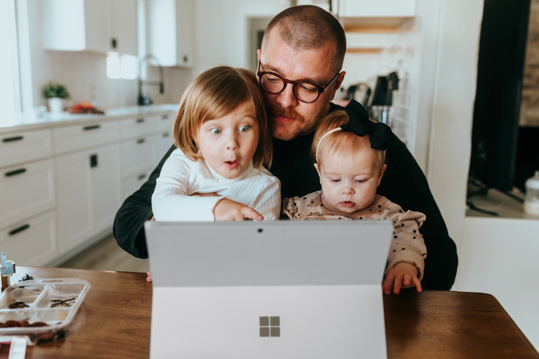 Family gathered around a laptop discussing online safety and AI scams