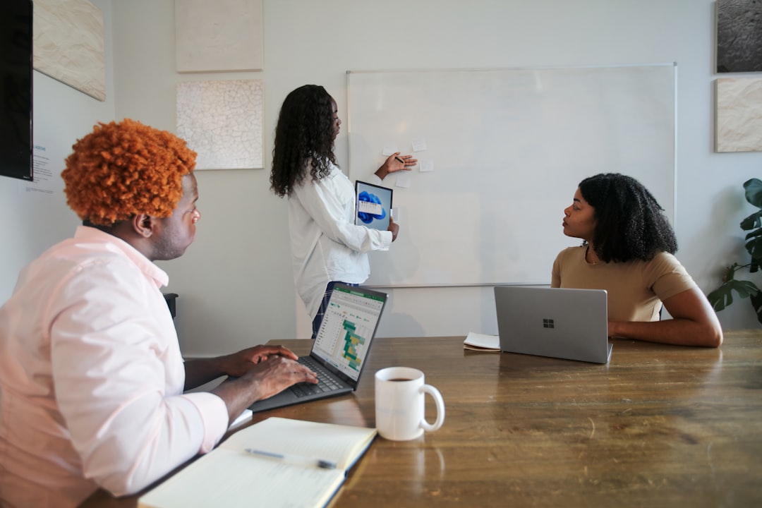 Marketing team planning SEO strategy around a whiteboard with charts