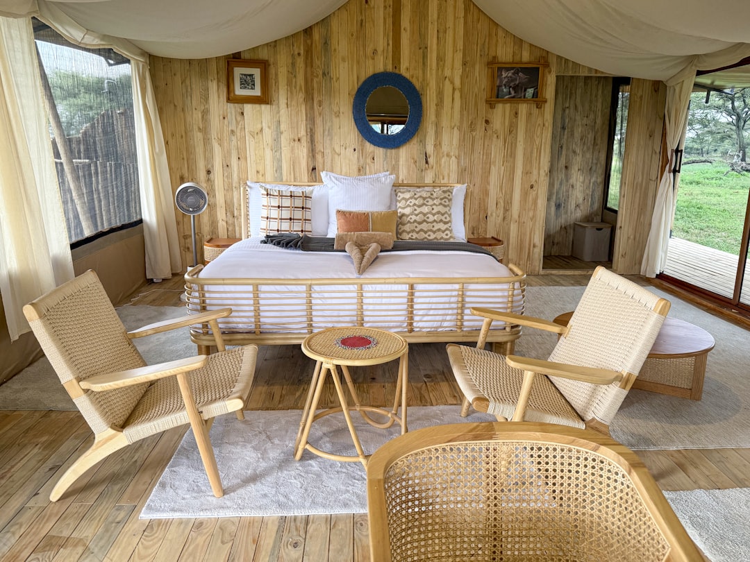 Interior of a spacious canvas bell tent with a cozy bed, rug, and small table
