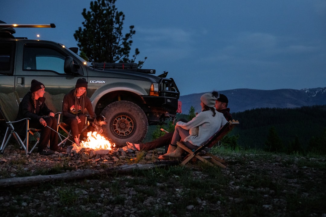 Friends sitting around a campfire at a private campsite under a starry sky