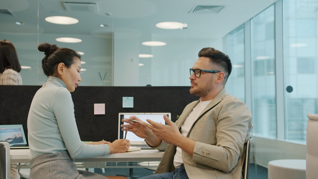 Humanoid robot standing in a modern office next to employees discussing a project