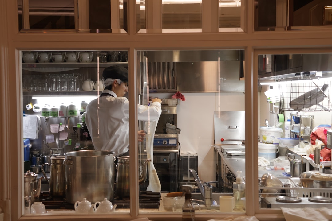 Humanoid robot working alongside a chef in a busy commercial kitchen