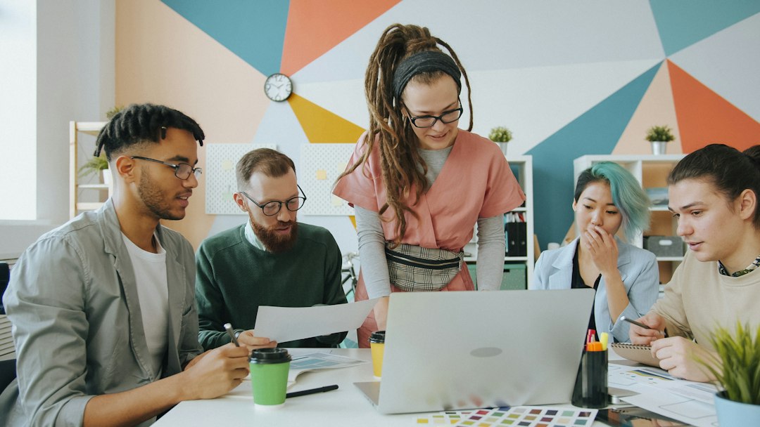 Group of people at a hackathon collaborating on laptops