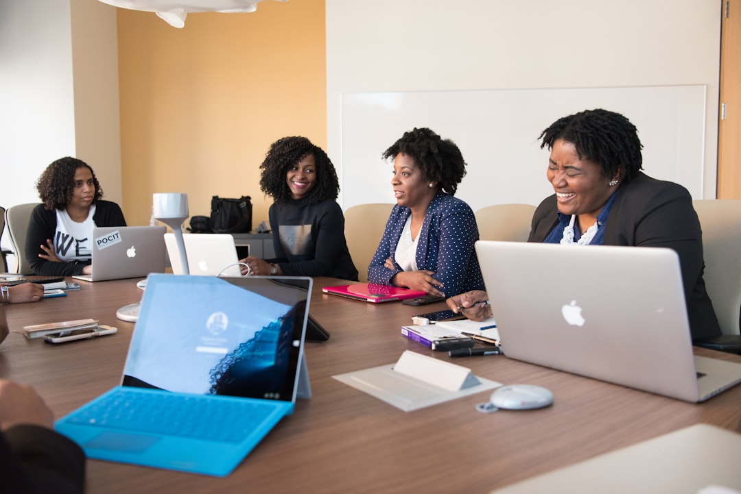 Executives using AI tools on a laptop during a boardroom meeting