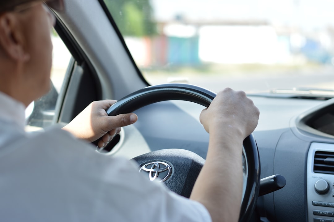 Driver sitting inside a compact Suzuki Alto navigating city traffic