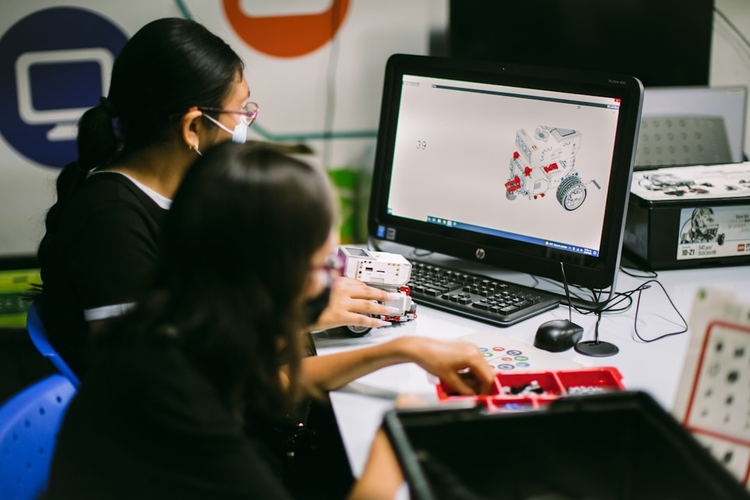Teacher working with a student at a computer displaying an AI chatbot