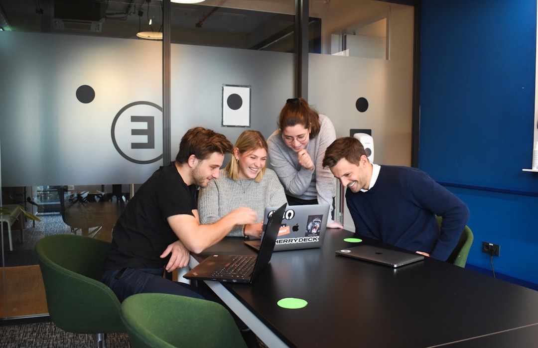 Colleagues planning workflow automation using laptops and diagrams