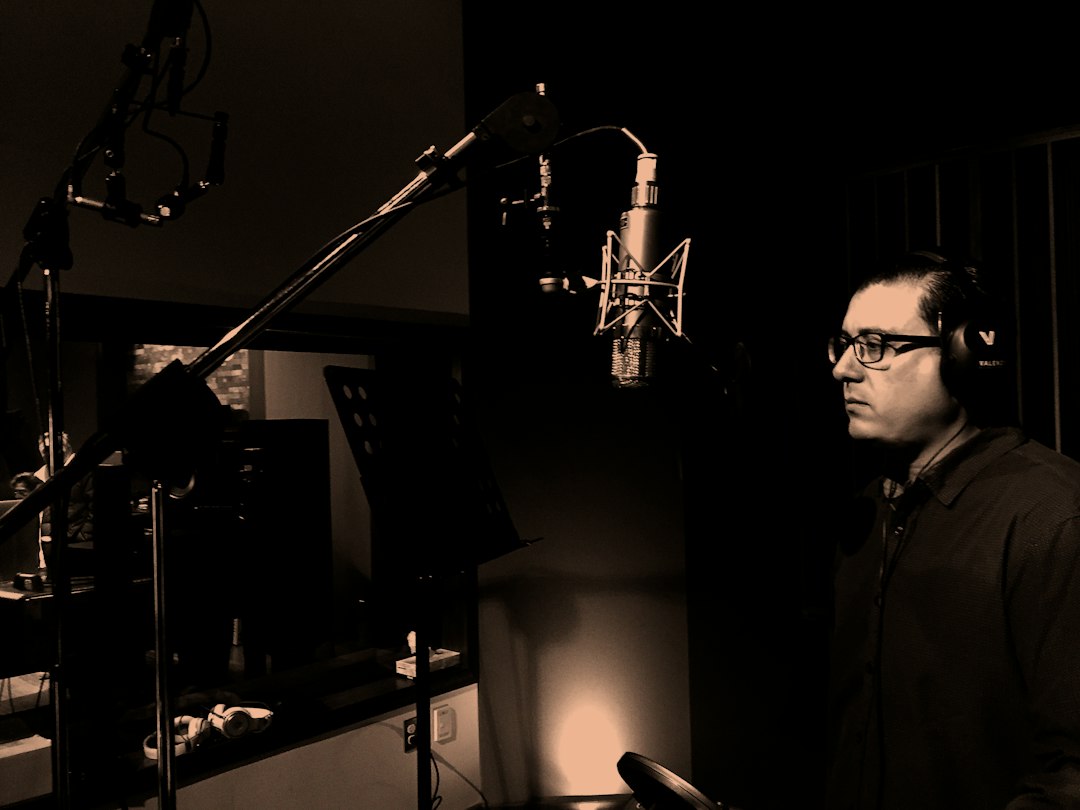 Man speaking into a microphone, practicing his voice